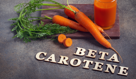 Porkkanoita ja porkkanamehua sek&auml; teksti betacaroten