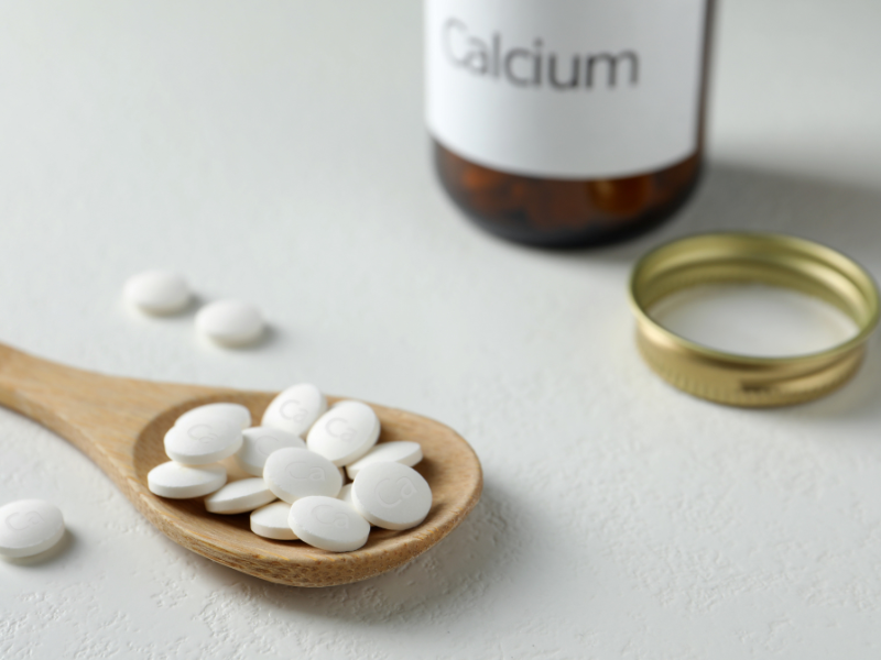 Kalsium purkki ja kalsiumtabletteja puulusikassa