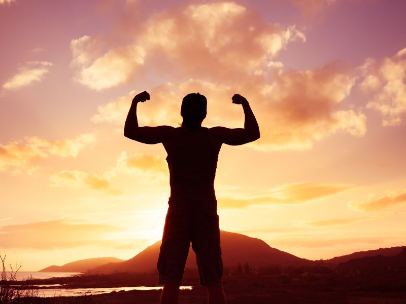 Mies seisoo auringonlaskussa ja n&auml;ytt&auml;&auml; hauiksia