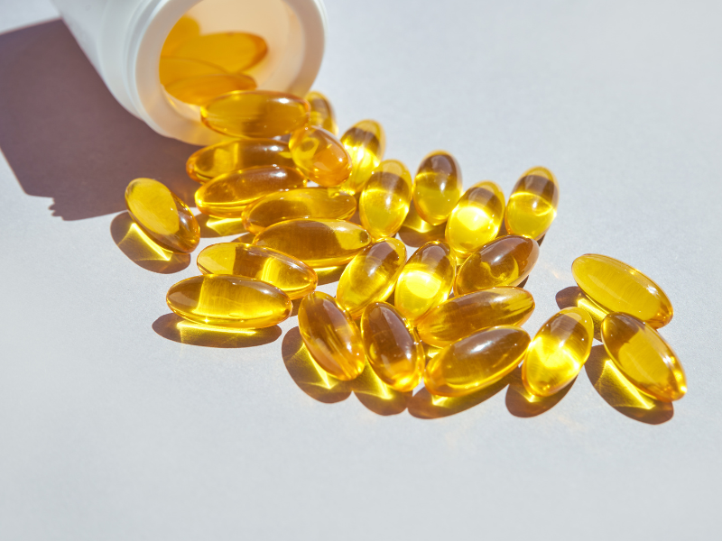 Kullankeltaisia  omega3- tabletteja tulee ulos purkista p&ouml;yd&auml;lle