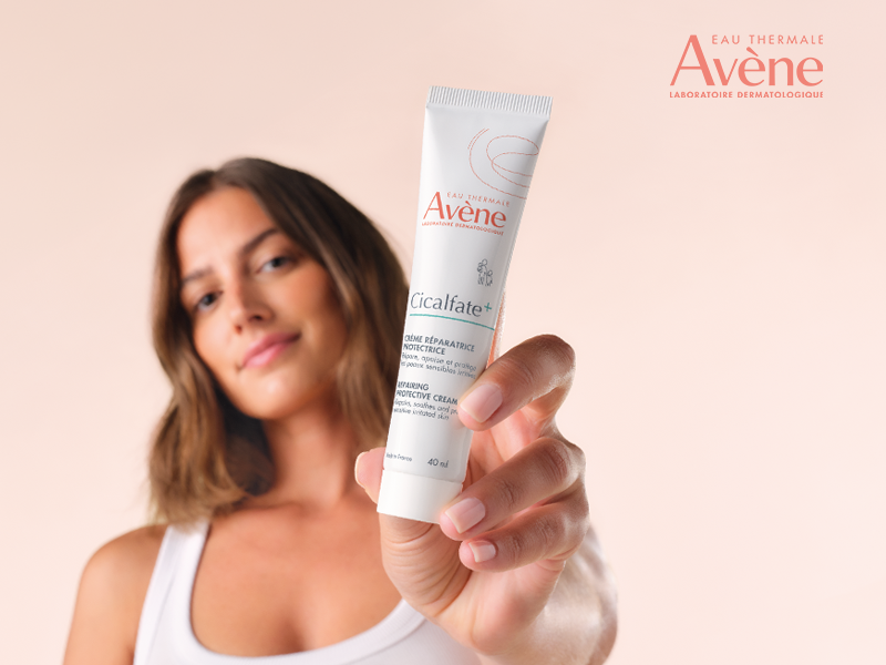 Nainen pitelee k&auml;dess&auml;&auml;n avenen cicalfate voidetuubia